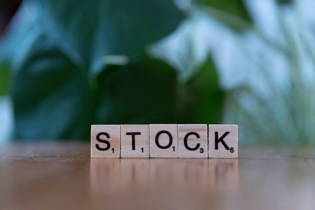 Bloque de madera con la palabra stock sobre mesa, diferencia fiscal entre fondos y acciones