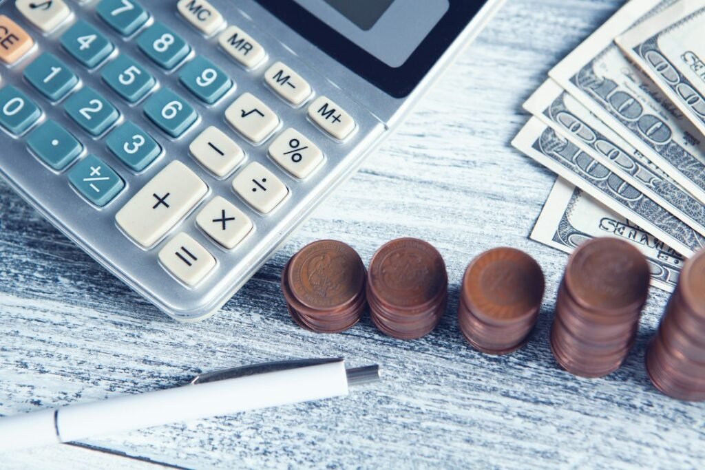 Calculadora, bolígrafo y dinero sobre una mesa, para saber si la Renta sale a pagar o a devolver