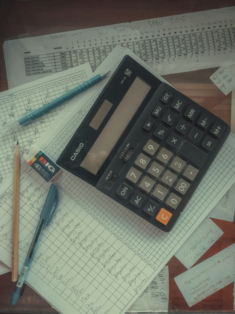Calculadora sobre un montón de papeles, para declarar inversiones como no residente fiscal