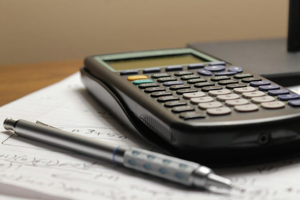 Calculadora y bolígrafo sobre una hoja de papel, para saber si hay obligación de declarar la Renta
