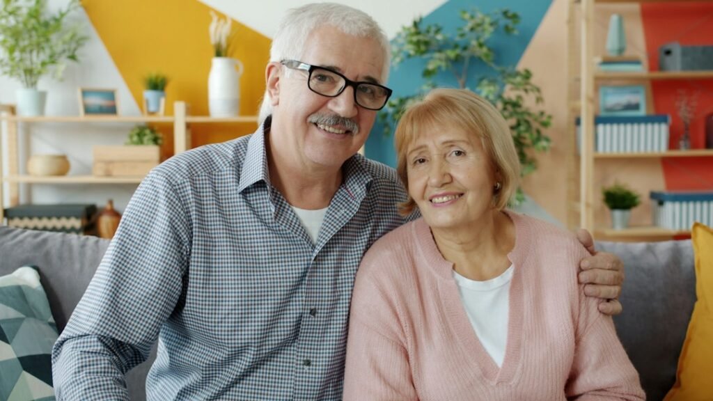 Pareja mayor sonriendo en el sofá, cómo rescatar un plan de pensiones por desempleo o enfermedad