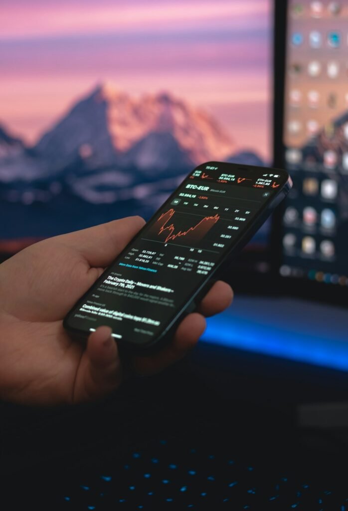 Persona sosteniendo un smartphone negro, comparando XTB e Interactive Brokers