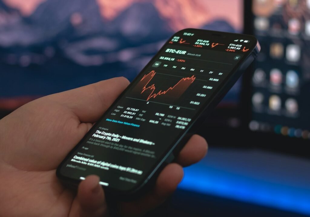Persona sosteniendo un smartphone negro, comparando XTB e Interactive Brokers