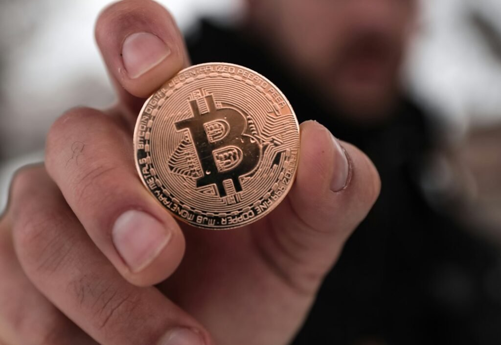 Persona sosteniendo una moneda, sanciones de Hacienda por no declarar criptomonedas