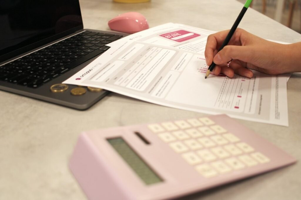 Persona trabajando con papeles y calculadora, para el checklist antes de presentar la Renta