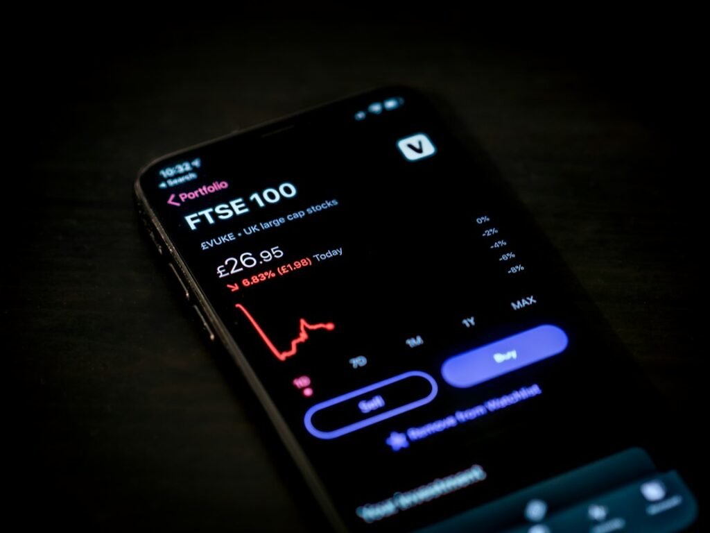 Persona usando el móvil con una app de gráficos financieros, para llevar el control fiscal de su cartera