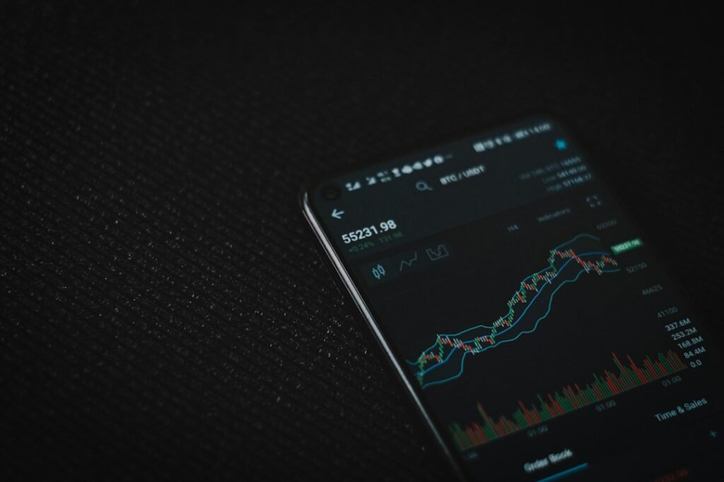 Smartphone negro mostrando gráficos de mercado, comparando MyInvestor y Trade Republic